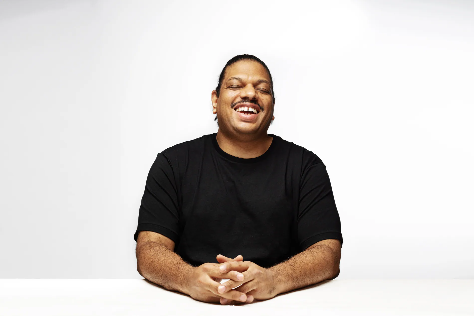 Kerri Chandler laughing press portrait on white background, shot by Joe Finch